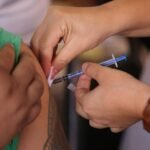 Medical professional giving an injection to a patient, emphasizing health and treatment.